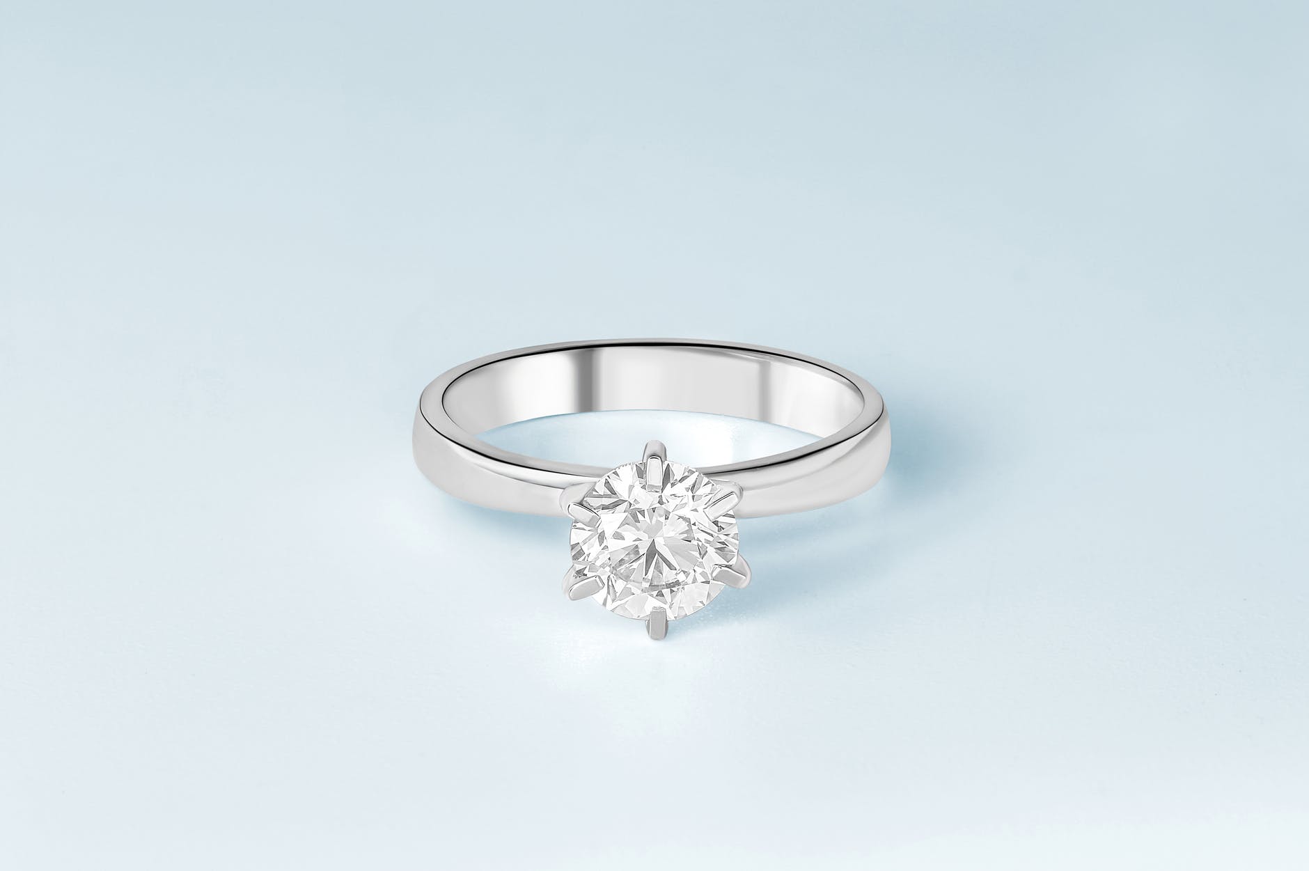 silver diamond studded ring on white surface
